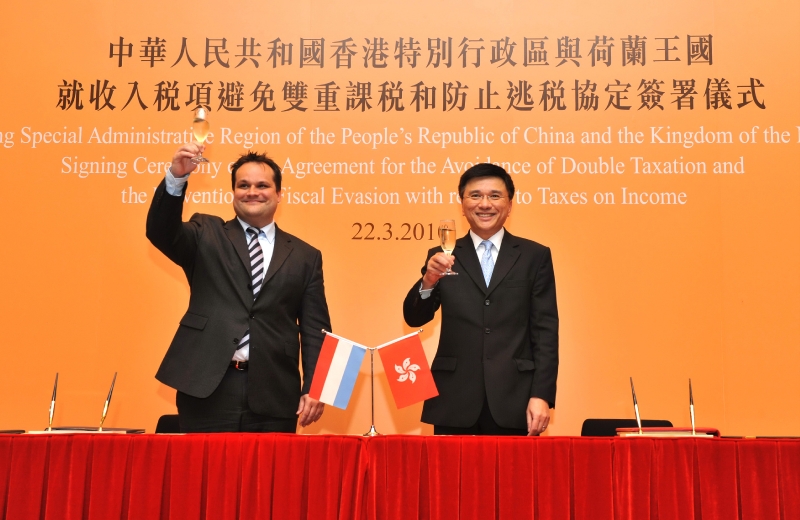 Professor Chan (right) and Mr De Jager propose a toast after signing the comprehensive agreement for avoidance of double taxation between the Hong Kong Special Administrative Region and the Kingdom of the Netherlands.