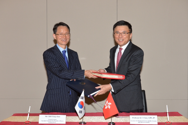 Professor Chan (right) exchanges documents with Mr Cho after signing the agreement.