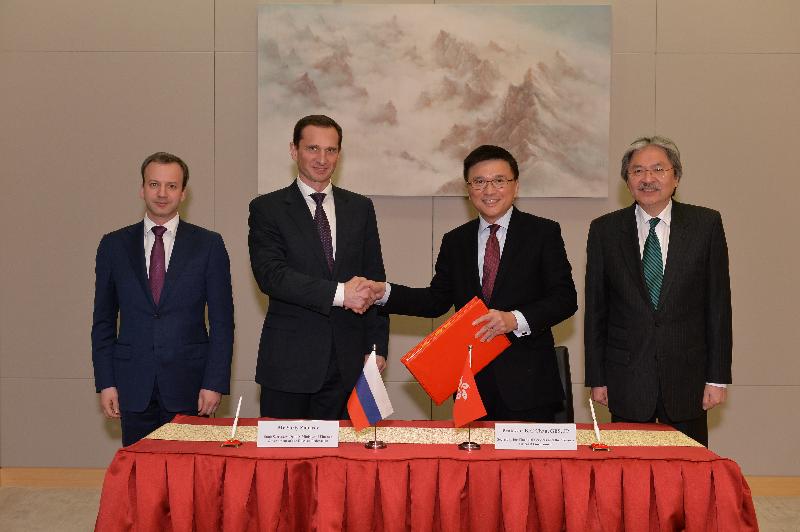 Professor Chan (third left) exchanges documents with Mr Yuriy Zubarev (second left) after signing the agreement.