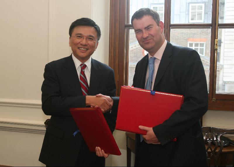 陳家強(左)與 Mr Gauke 簽訂全面性避免雙重徵稅協定後，互相交換文件。