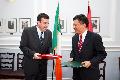 Professor Chan (right) and Mr Lenihan exchange documents after signing the comprehensive agreement for the avoidance of double taxation.