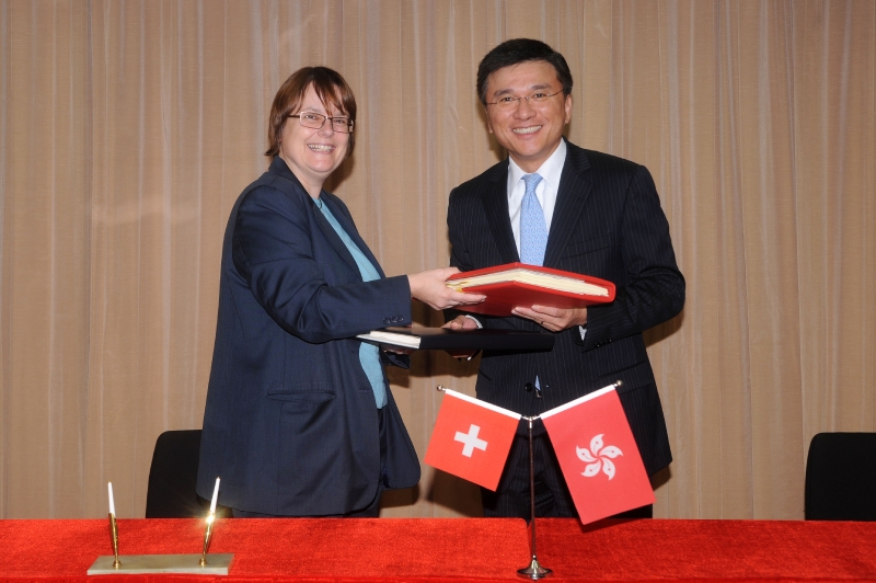 Professor Chan and Mrs Hammerli-Weschke exchange documents after signing the agreement.