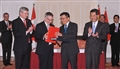 Professor Chan (second right) exchanges documents with Mr Fast (second left) after signing the agreement. 