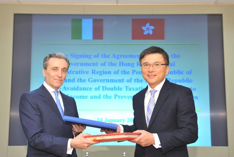 Professor Chan (right) and Professor Grilli exchange documents after signing the treaty. 
