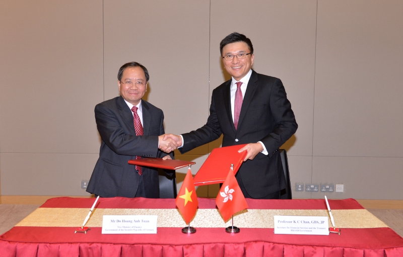 Professor Chan (right) exchanges documents with Mr Do Hoang Anh Tuan after signing the second protocol