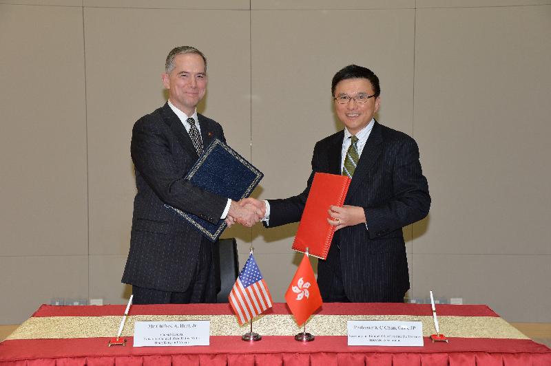 Professor Chan (right) and Mr Hart exchange documents after signing the treaty
